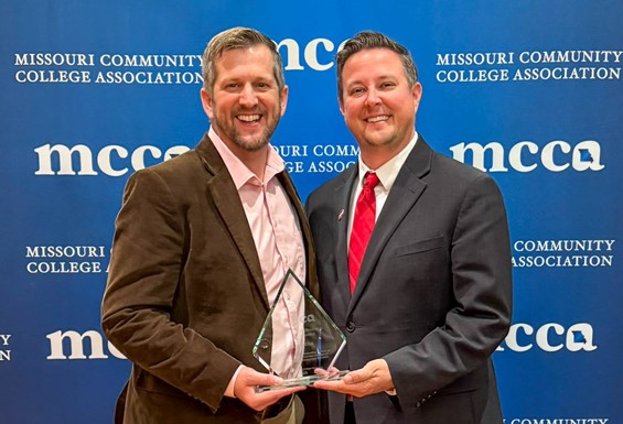 Dan Jaycox and Dr. Joe Gilgour holding award in front of MCCA backdrop